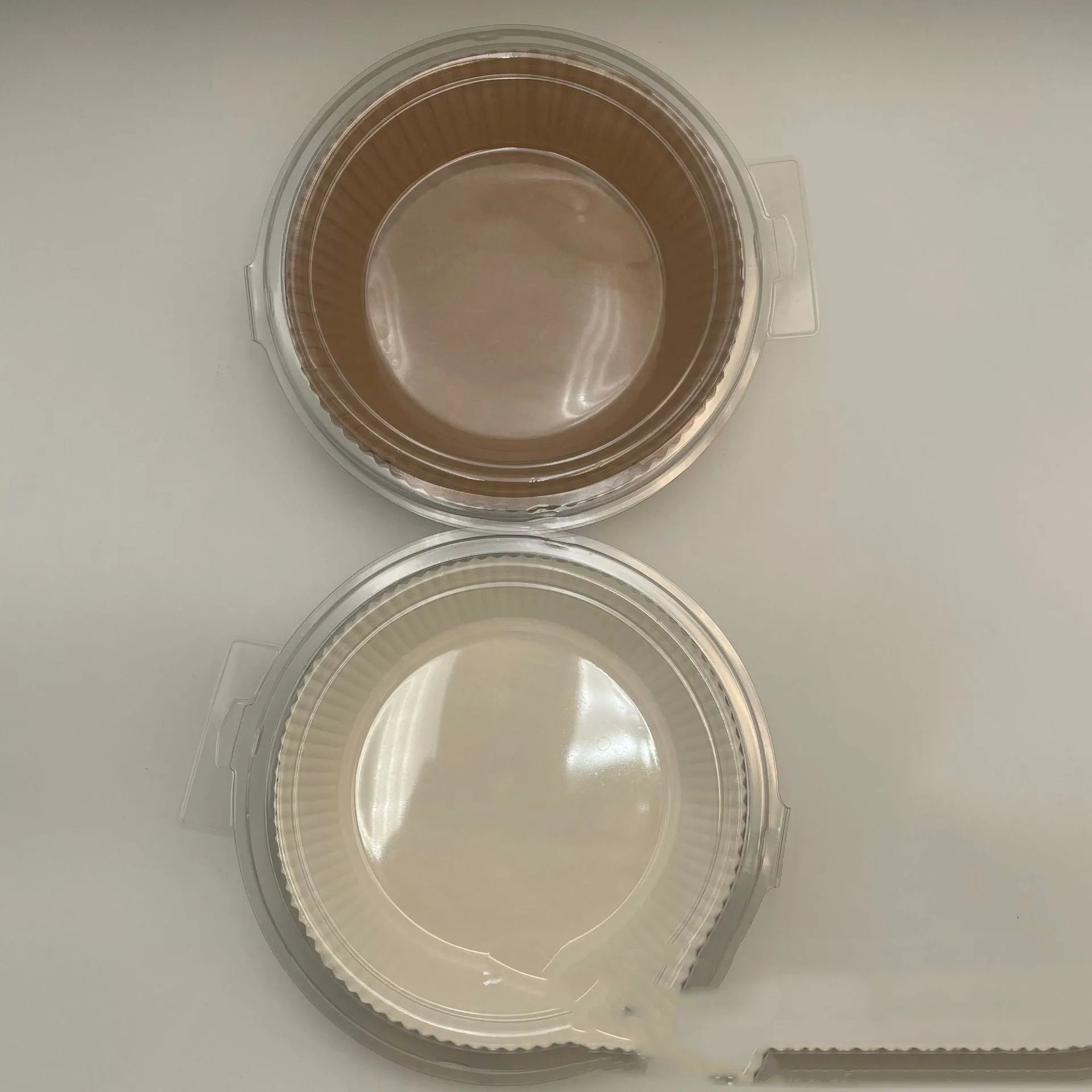 Round white disposable parchment paper liner for air fryer basket with raised edges.