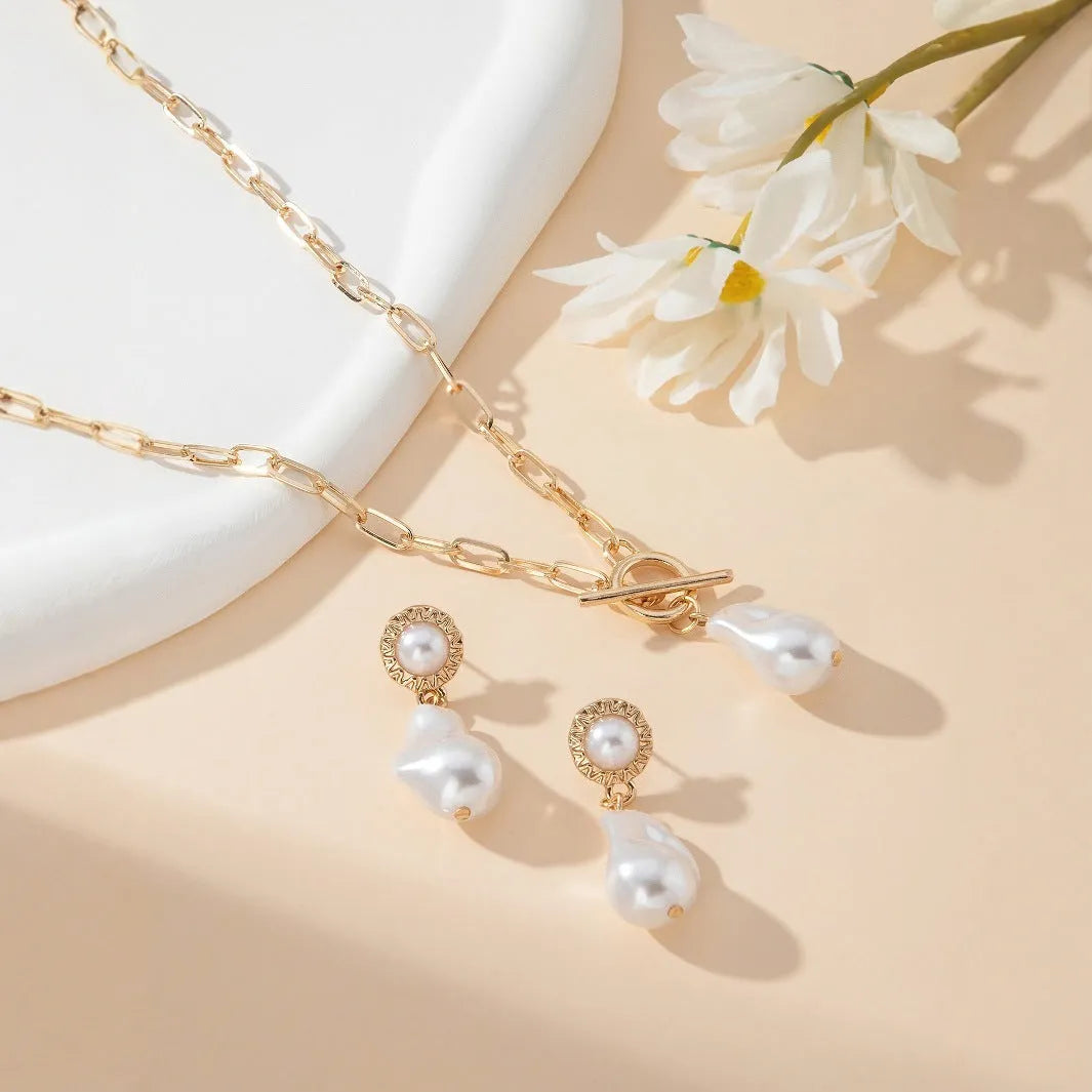Gold colour baroque pearl necklace and earring set with retro design on dark background