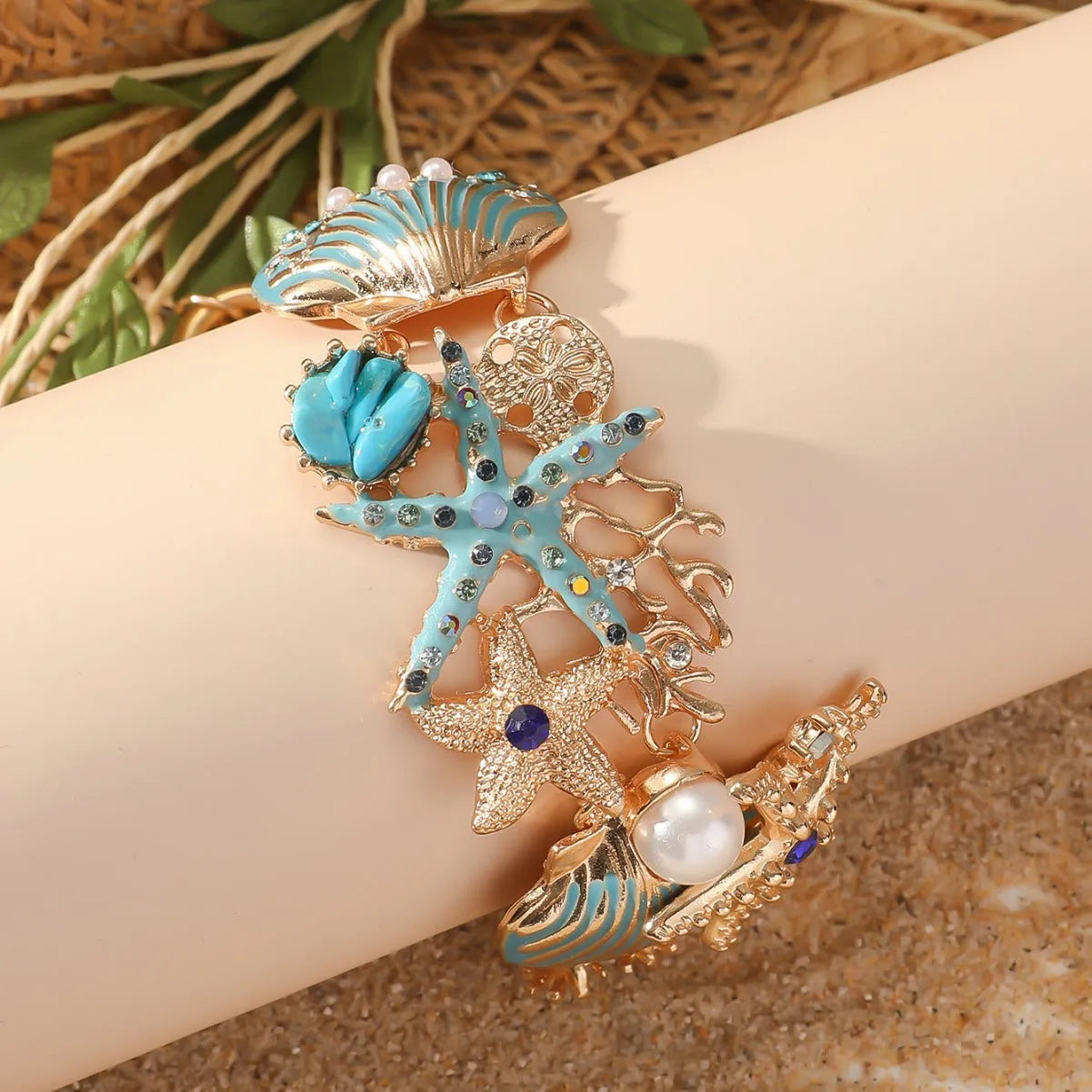 Women's alloy marine bracelet with starfish and anchor detailing in turquoise, red or blue coral colour.