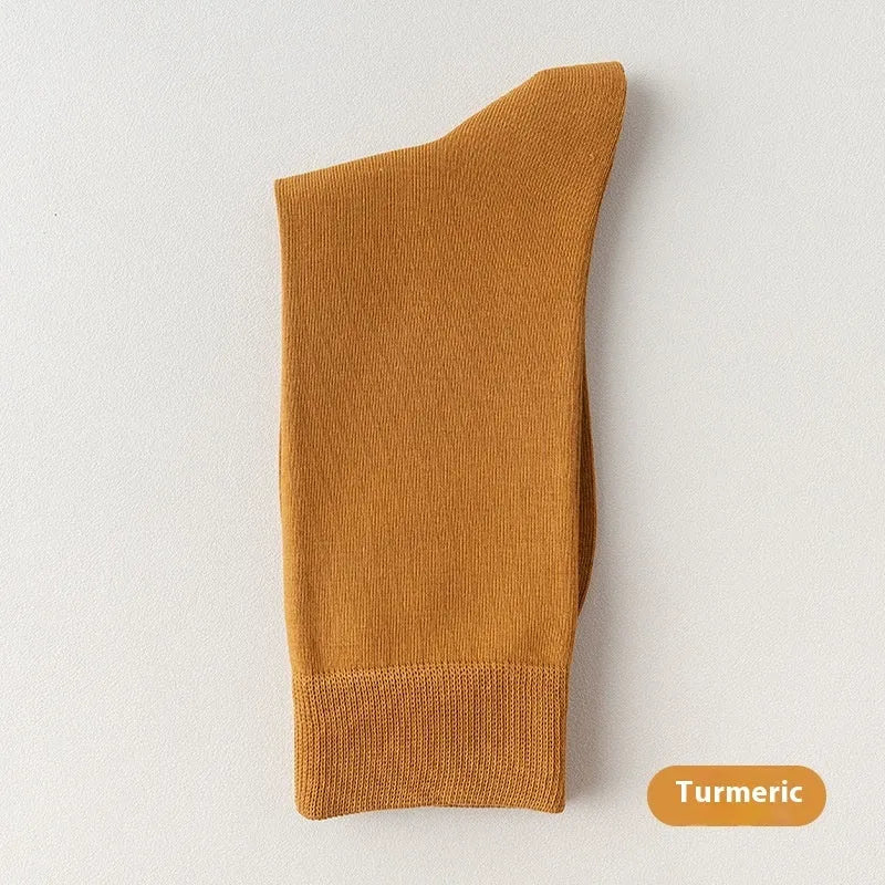 Men's mid-calf combed cotton socks in solid colours like army green, beige, and black on a white background.
