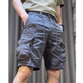 A model wearing loose-fit, straight-leg, multi-pocket overalls trousers in a khaki colour.