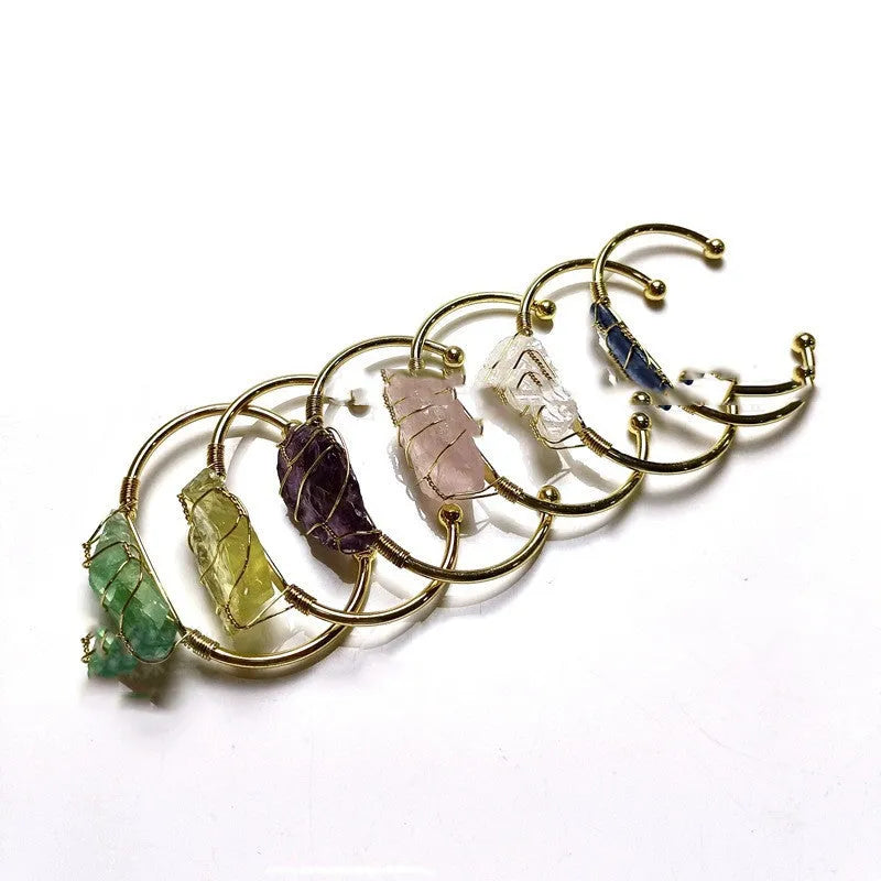 Unisex geometric bracelet with rough natural crystals and gold winding metal on a wrist.