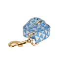 Blue cloth dog vest harness set with matching collar, leash, and decorative bow tie on a small dog