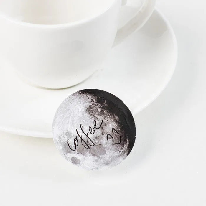 Black moon phase, planet, and calendar design stickers on a sheet, 45 pieces total.