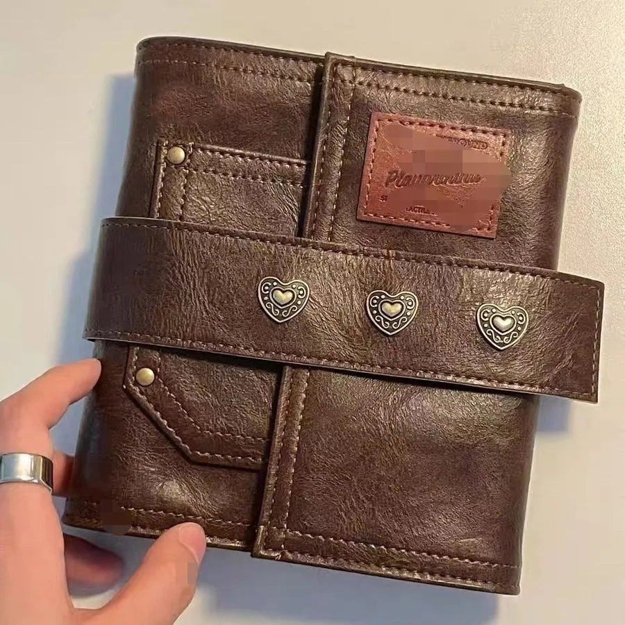 Brown retro-style notebook with a buckle closure and loose-leaf binder binding