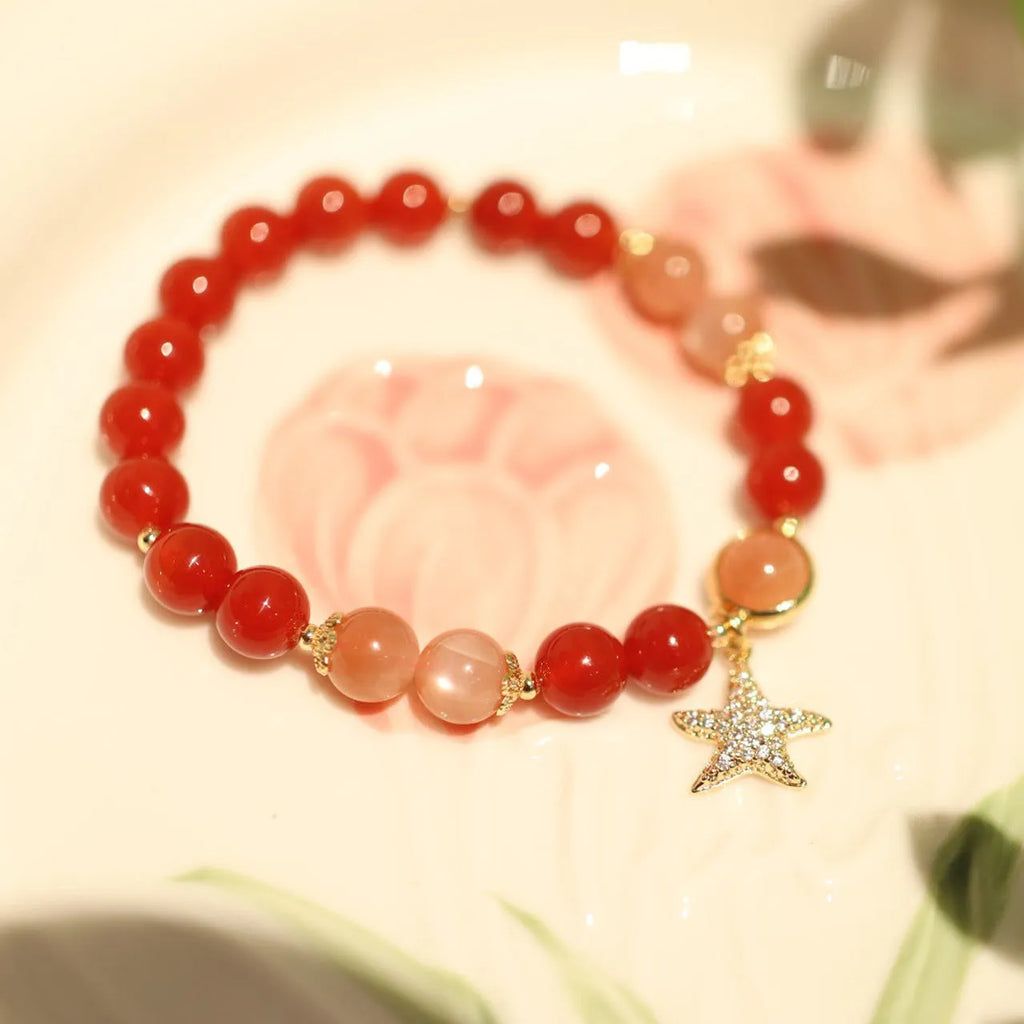 Handmade ethnic-style bracelet with sand orange Sunstone and 8mm red agate beads in a star pattern.