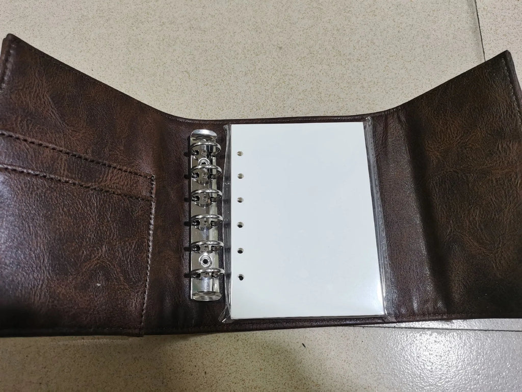 Brown retro-style notebook with a buckle closure and loose-leaf binder binding