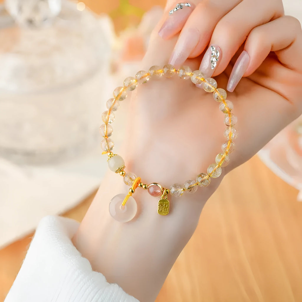 Gold rutilated quartz crystal bracelet with safety buckle closure and geometric pendant