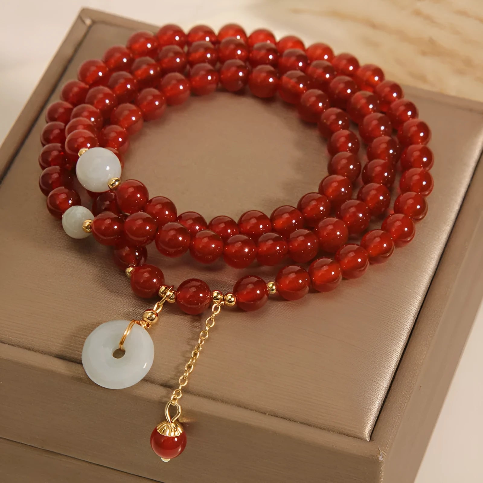 Women's multi-layer bracelet with red agate stones and crystal embellishments on adjustable band