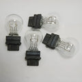 Wagner dual-wire brake light bulb with yellow glass and plastic orientation dot.