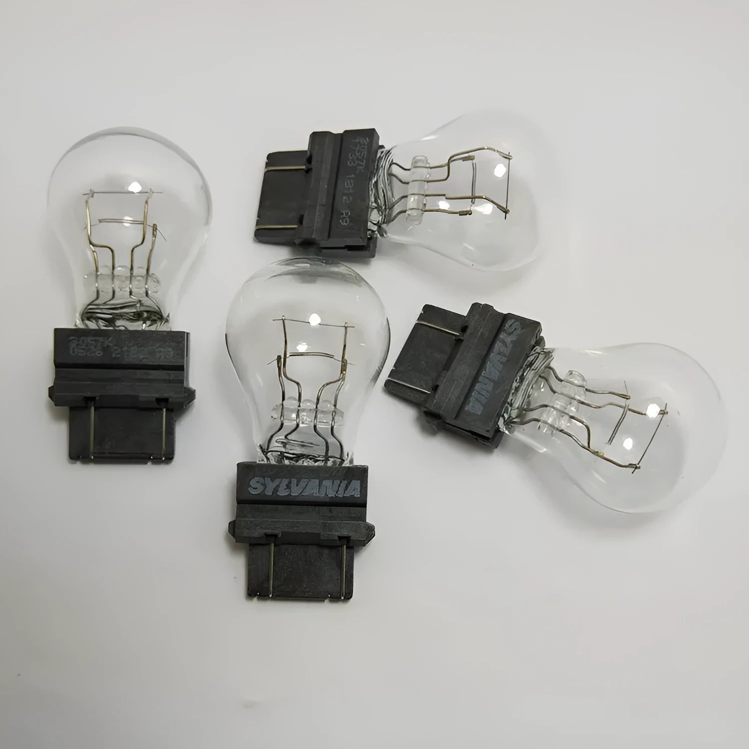 Wagner dual-wire brake light bulb with yellow glass and plastic orientation dot.