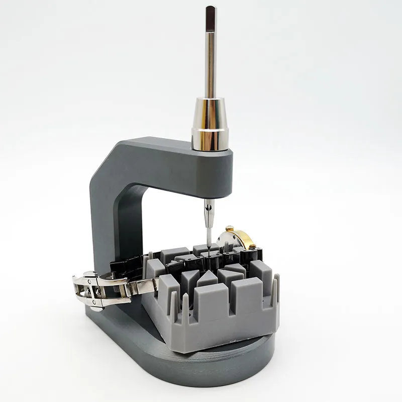Silver tool steel press strap removal tool for watch bands and jewellery on a grey background.