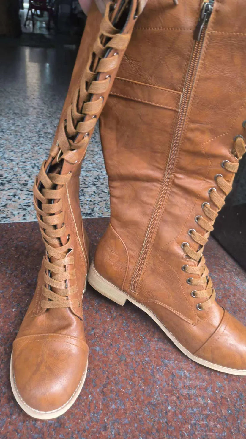 Women's black synthetic PU knight boots with a cross-strap design on the upper.