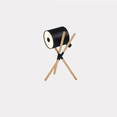 Modern wooden three-prong floor lamp with an acrylic shade in a living room setting.