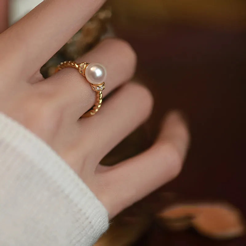 Adjustable antique twist copper ring with a central pearl inlay, shown in gold and silver tone finishes.
