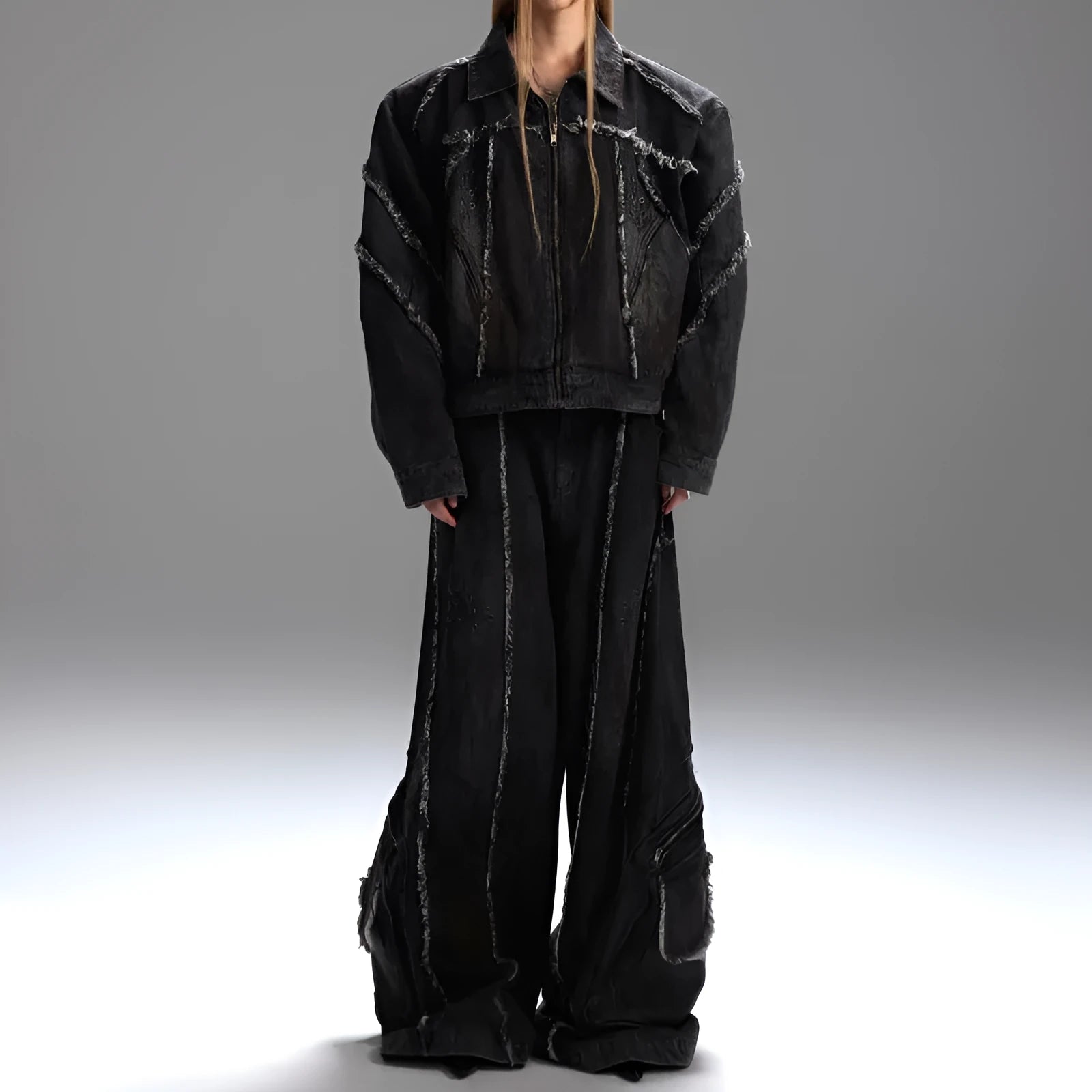 Black gradient distressed denim coat with padded shoulders and matching trousers, featuring raw edges and splash-dye finish.