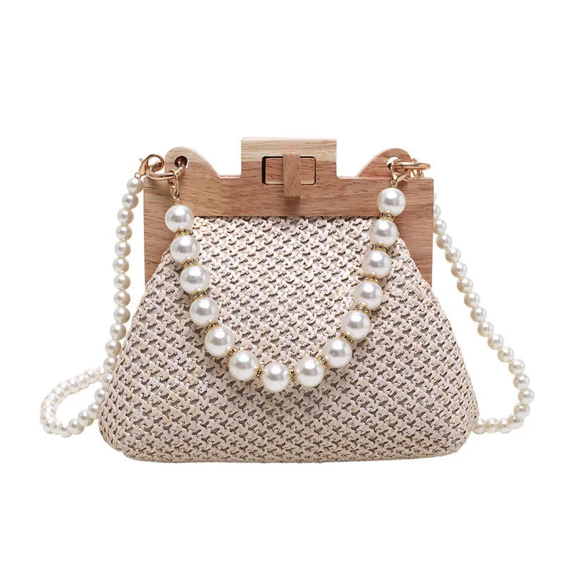 Women's woven straw shoulder bag with pearl chain strap showing interior organisation compartments