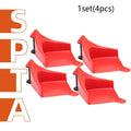 Set of four red triangular plastic car parking blocks or wheel stops on a grey background.