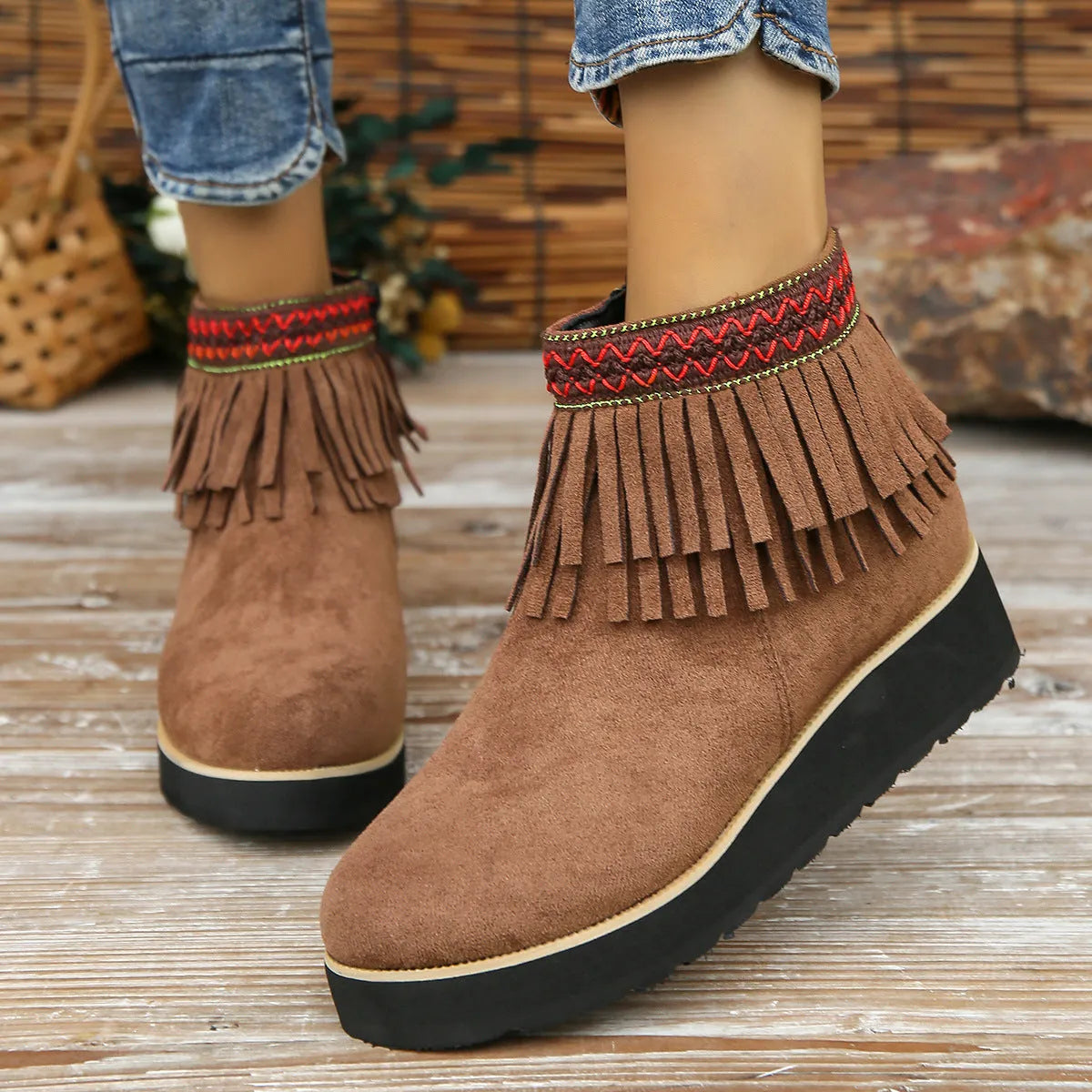 Women's dark brown suede ankle boots with wedge heel, platform sole, side zip, and tassel detail.