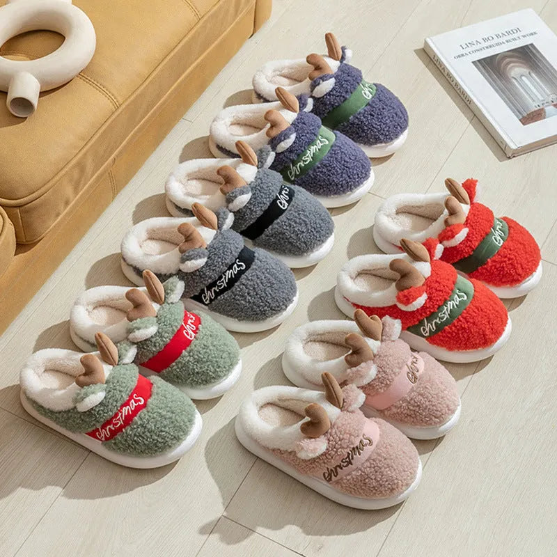 Pair of Christmas elk winter home slippers with suede upper and candy-coloured antler print on bedroom floor