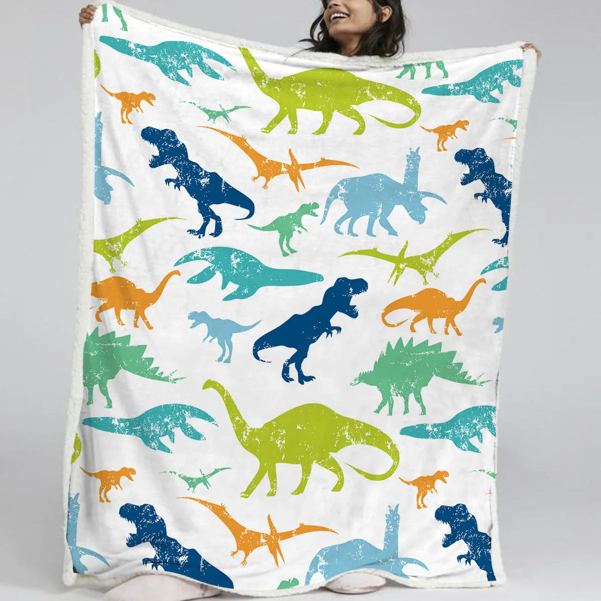 Dinosaur themed lamb wool blanket in white on a sofa, measuring 130x150cm or 150x200cm