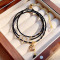 Close-up of a women's multi-layer bracelet with three blue gold sand stone rings on a wrist.