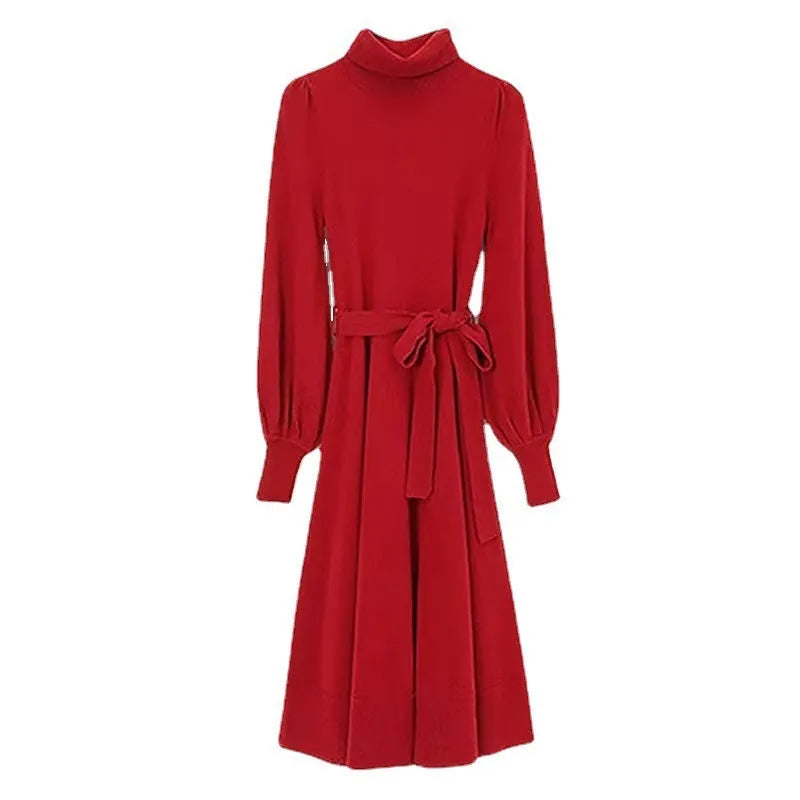 Adult woman wearing a rose red loose-knit turtleneck sweater dress with a flared midi skirt and elastic waist.