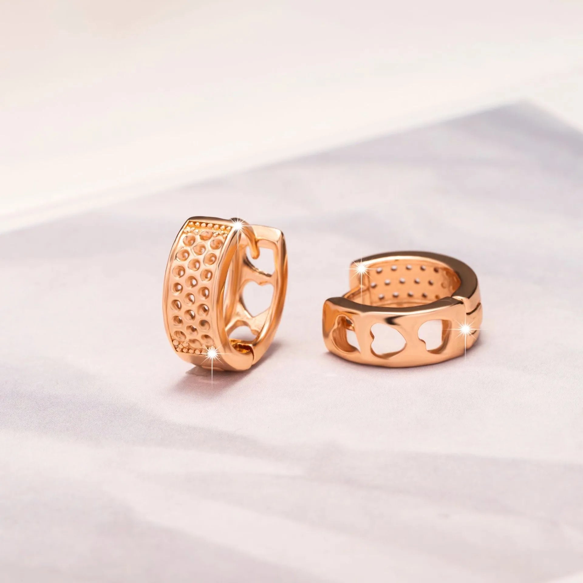 Rose gold women's earrings with three hollowed-out heart shapes in circular pattern