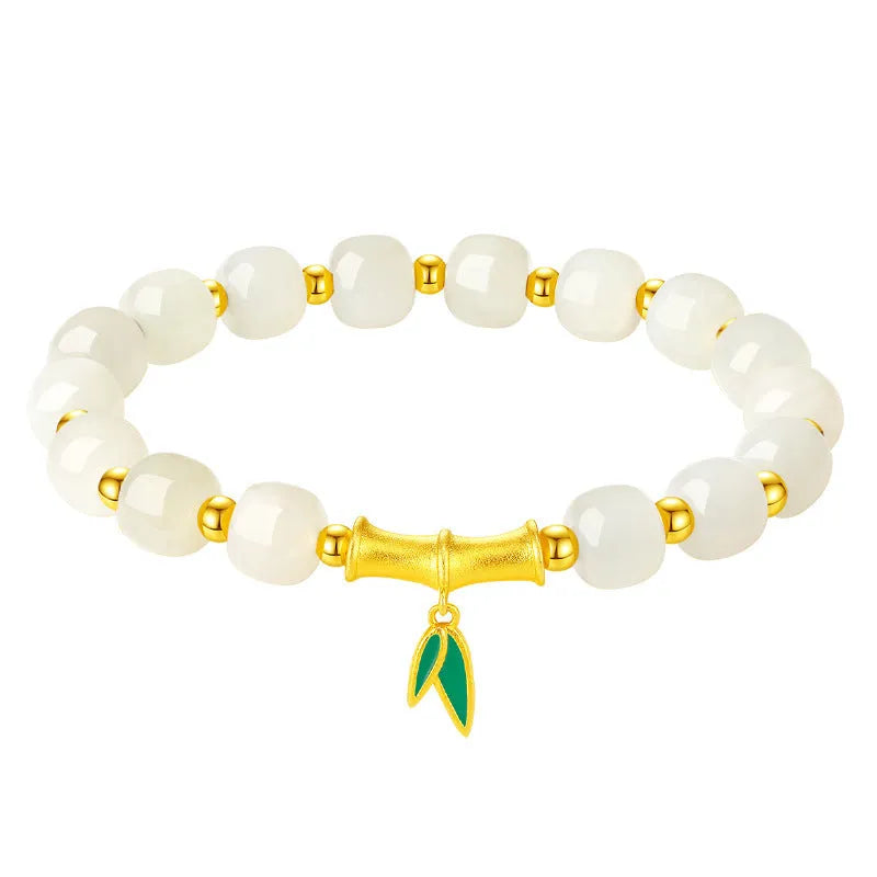 Natural Hetian jade and sterling silver bamboo leaf bracelet on a wrist, showing gold and silver finish options.