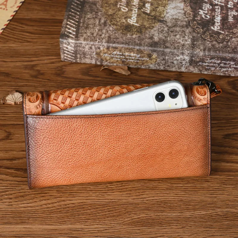 Women's brown cowhide tri-fold wallet with embossed floral pattern showing open compartments