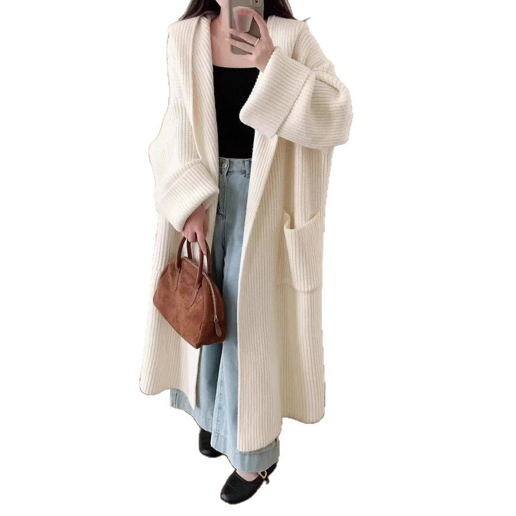 Loose grey hooded sweatshirt cardigan coat with raglan sleeves on a hanger.