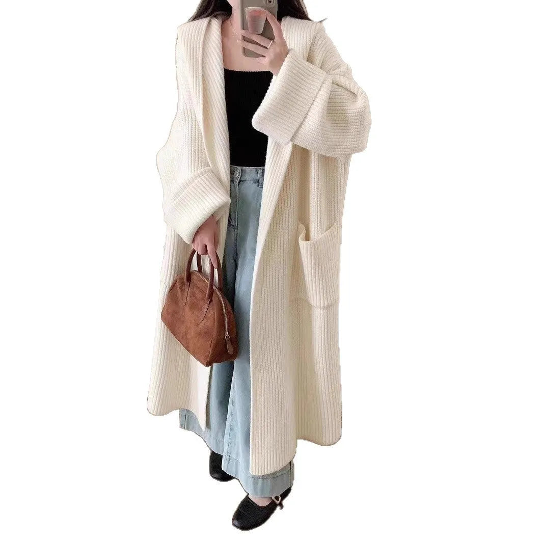 Loose grey hooded sweatshirt cardigan coat with raglan sleeves on a hanger.