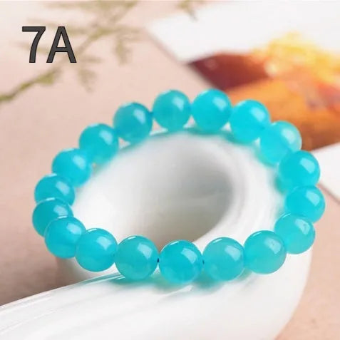 Natural blue-green Amazonite 7A grade scattered beads bracelet on a white background.