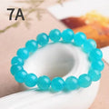 Natural blue-green Amazonite 7A grade scattered beads bracelet on a white background.