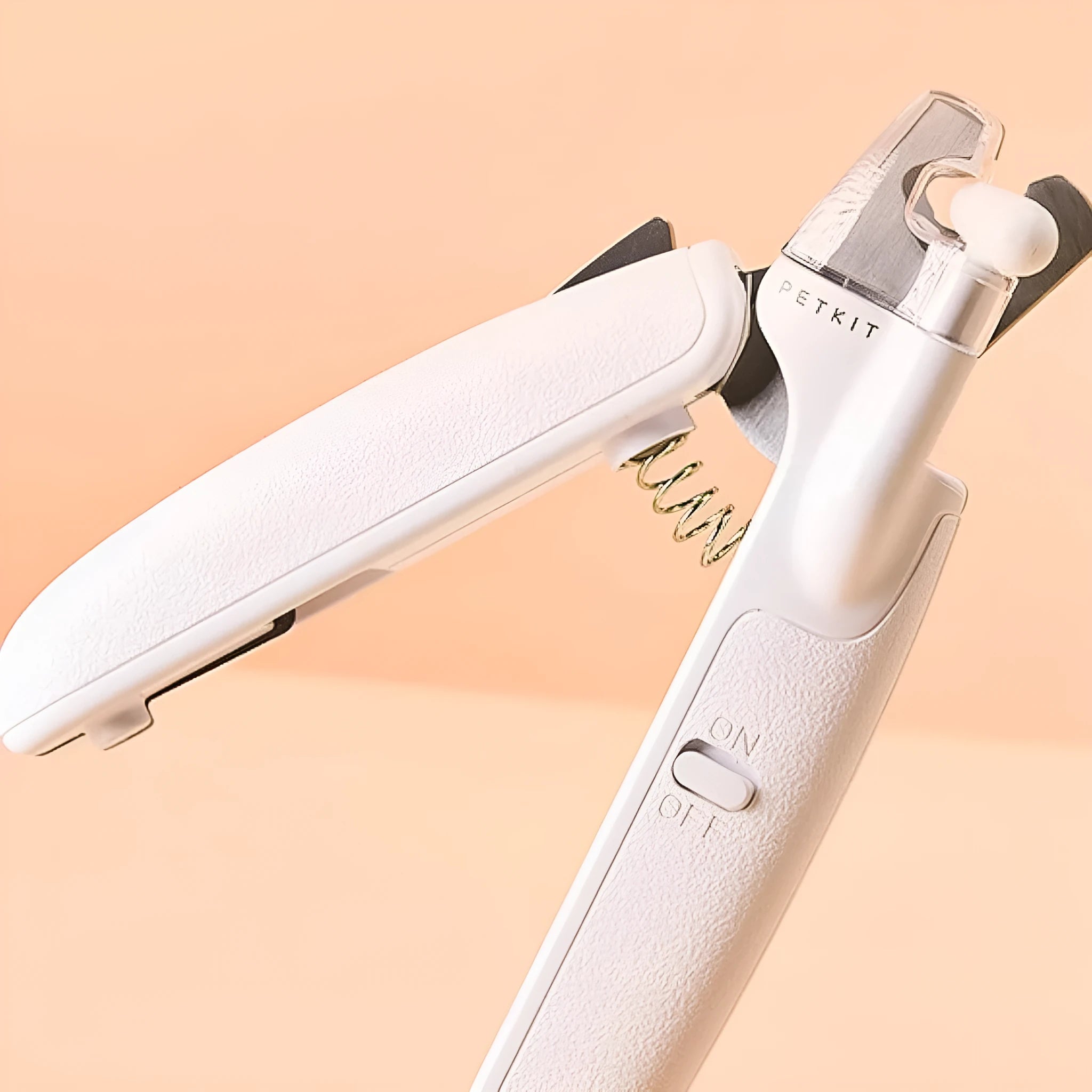White pet nail clippers with LED light on blade and transparent anti-splash guard, shown with a nail file.