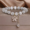 White cat's eye stone bracelet with flower tassel detail and morganite safety buckle pendant