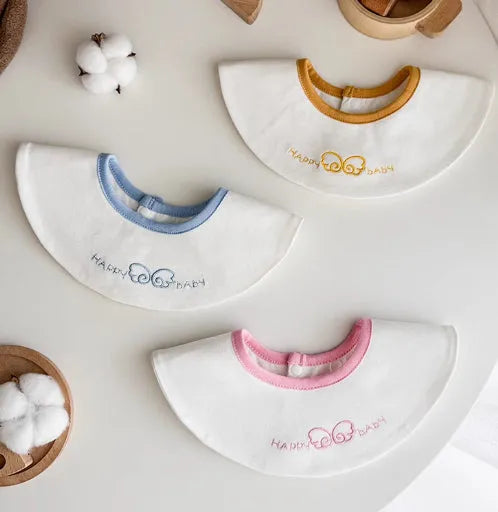 Set of three small cotton baby bibs in assorted colours with waterproof layer for milk spill protection