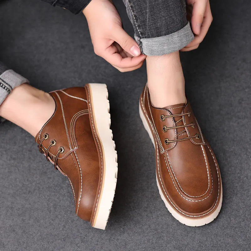 Men's low-top black Martin boots with round toe and rubber sole on a neutral background.