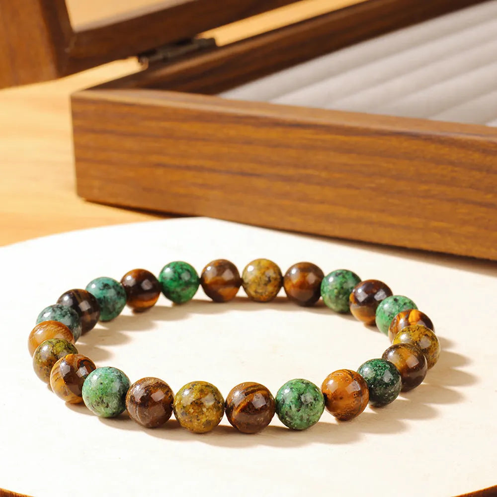 Handmade tigereye stone bracelet with 18mm flower bead in antique style on wrist.