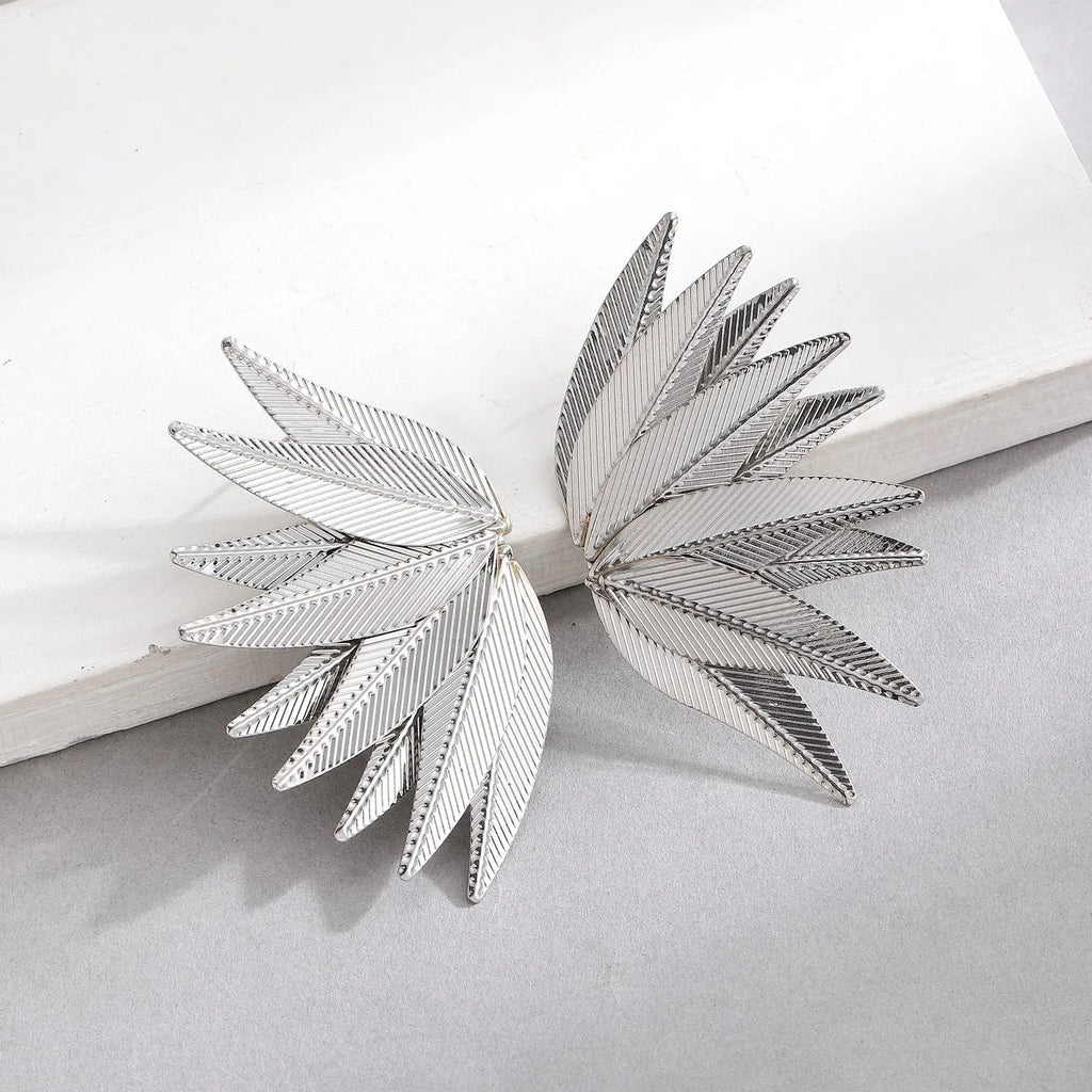 A pair of gold and white alloy patch earrings shaped like leaves.