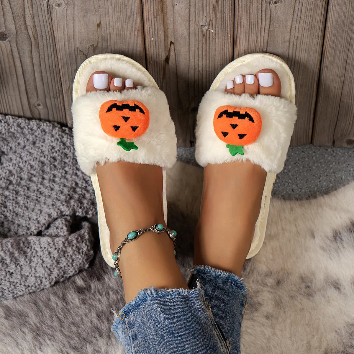Yellow Halloween pumpkin cartoon design plush slippers with synthetic fur and a light-coloured sole.