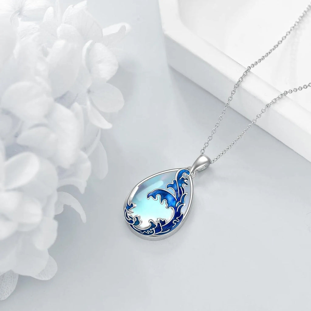Close-up of a moonstone blue heart-shaped alloy pendant on a necklace chain.