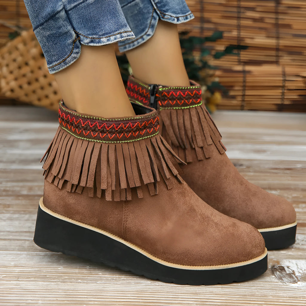 Women's dark brown suede ankle boots with wedge heel, platform sole, side zip, and tassel detail.