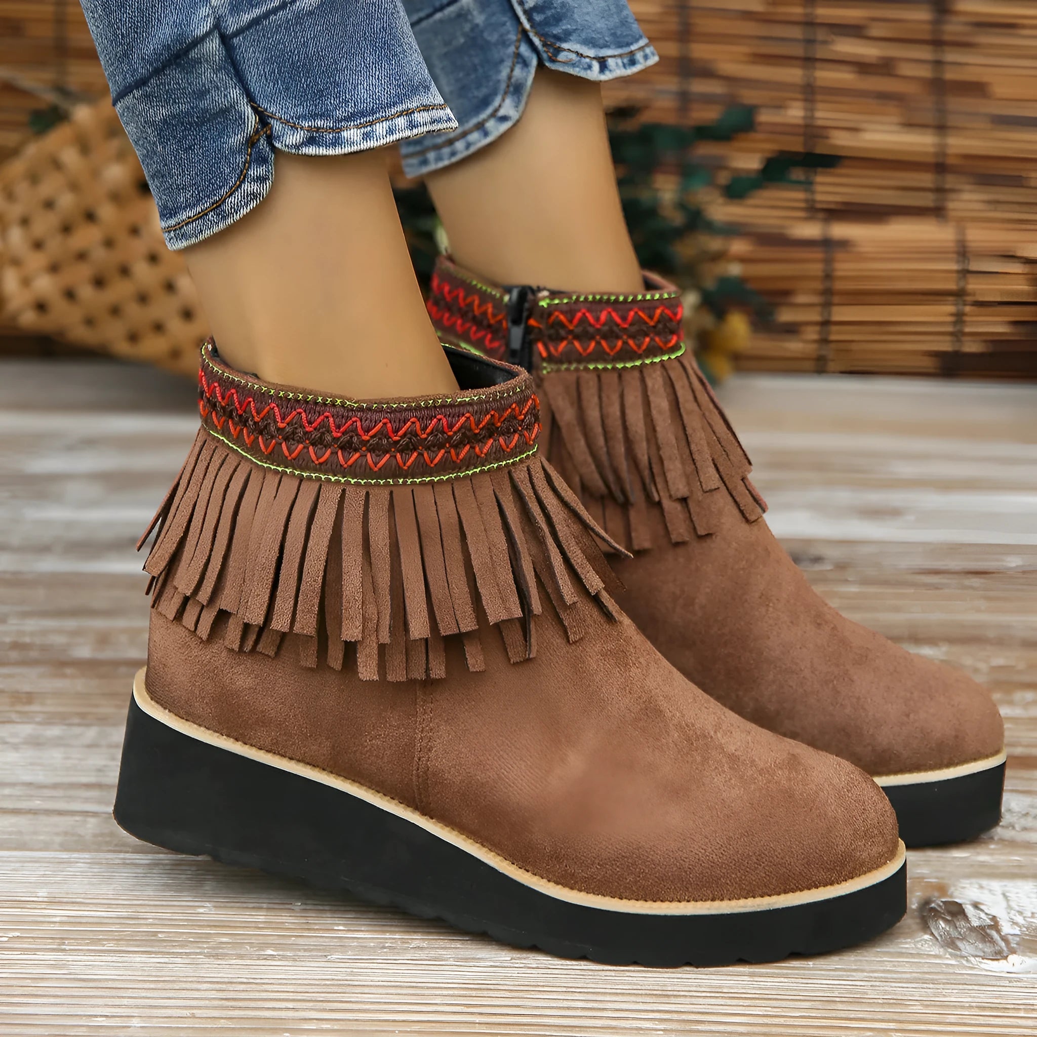 Women's dark brown suede ankle boots with wedge heel, platform sole, side zip, and tassel detail.