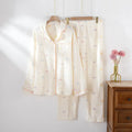 Women's cotton pajama set with long sleeves in pink colour showing top and trousers laid flat