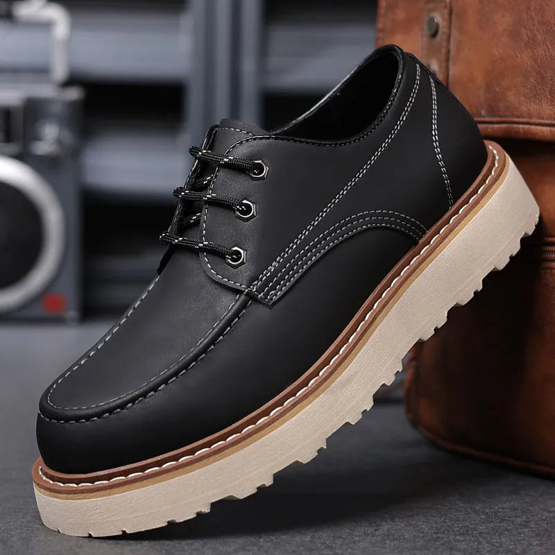 Men's low-top black Martin boots with round toe and rubber sole on a neutral background.