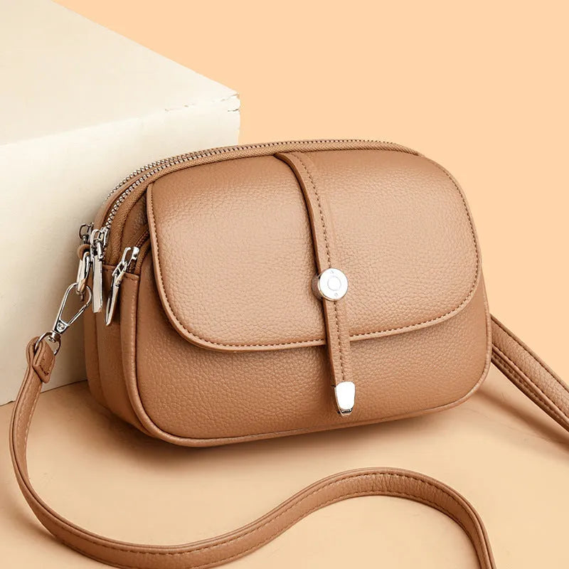 Soft black oval crossbody shoulder bag for women with visible stitching and a shoulder strap.
