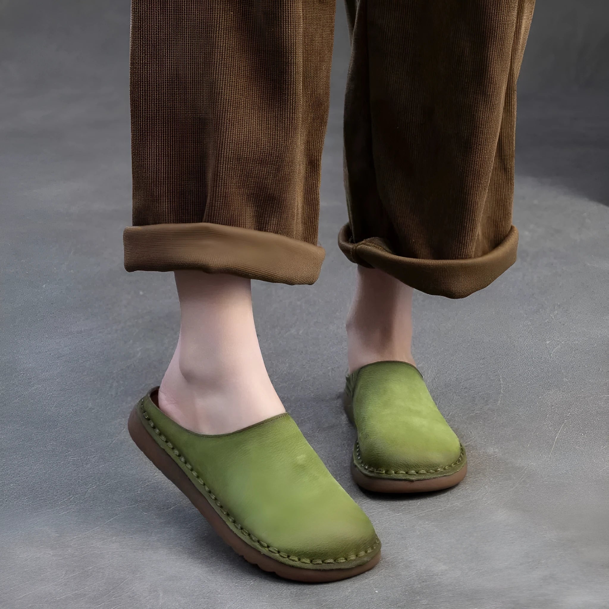 Genuine leather retro wrap-around lazy slippers in brown colour with rubber sole on a neutral background