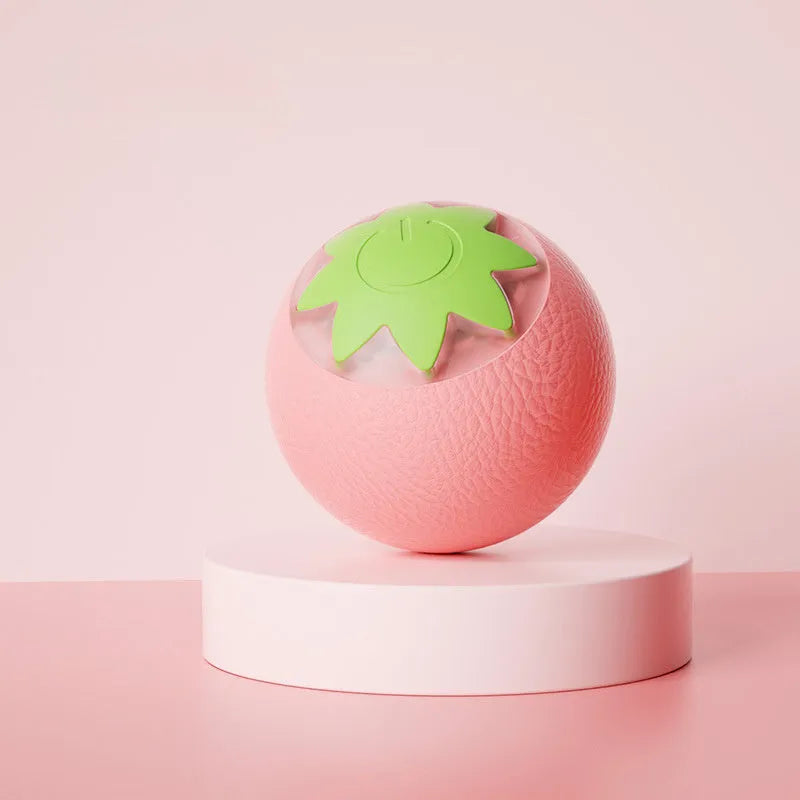 Small green automatic rolling ball toy for dogs and cats on a wooden floor.