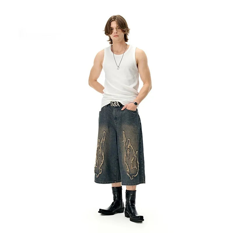 Men's black cropped denim shorts with patch flame embroidery on leg